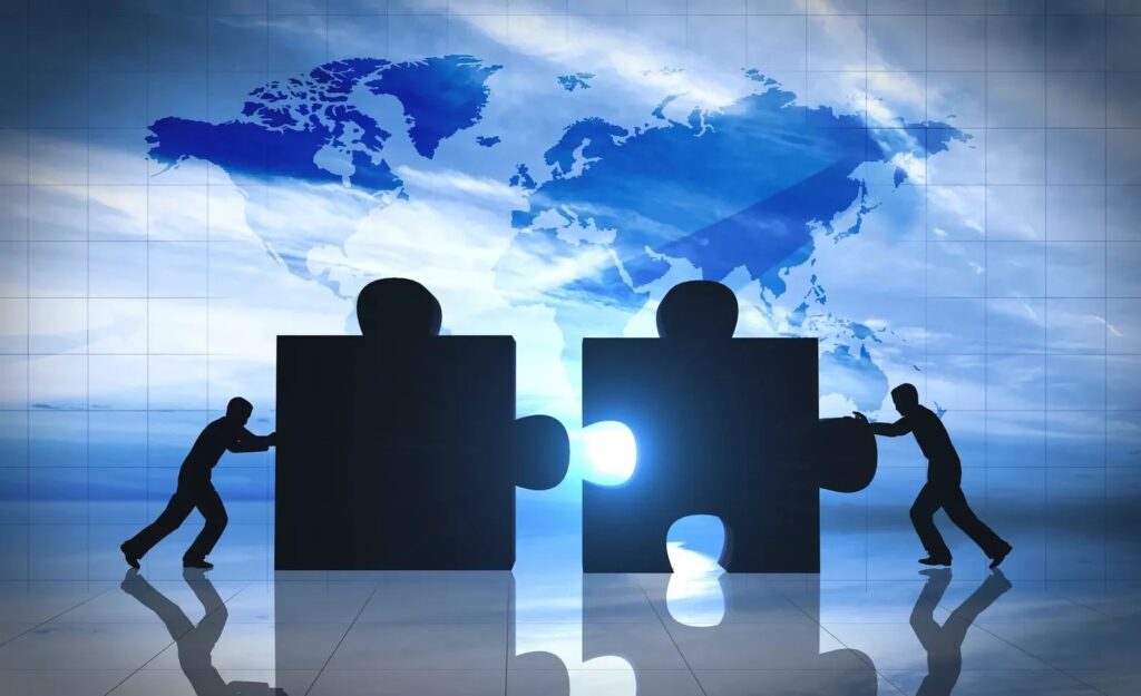 two persons pushing together pieces of puzzle narrating the concept of cooperation at World Economic Forum 2024